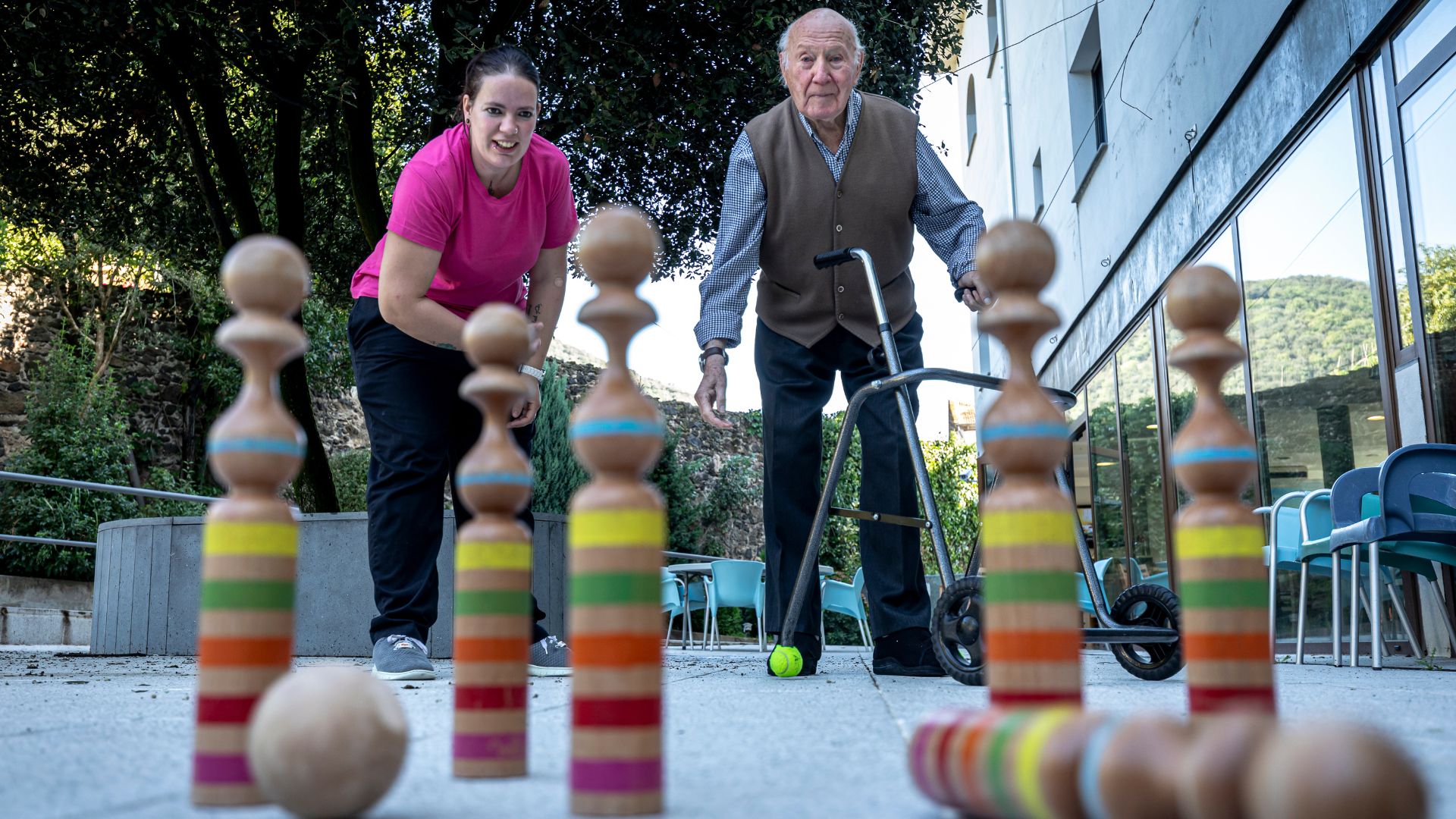 Residente y profesional jugando a bolos en el jardín de la residencia