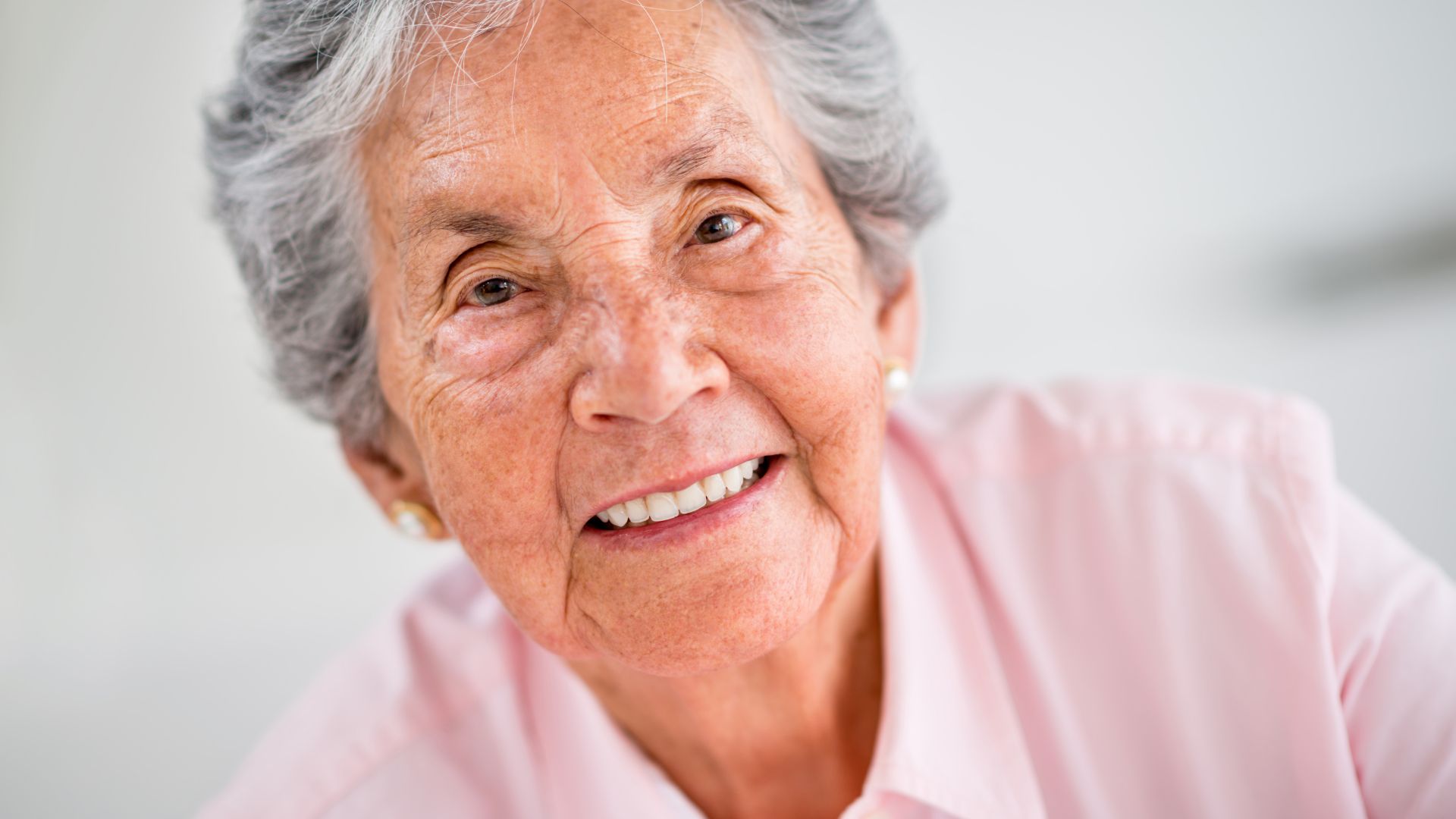 Mujer mayor, persona atendida mirando a cámara y sonriente