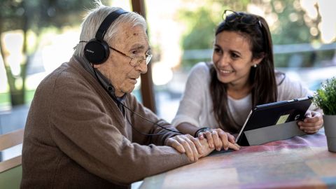 Profesional de Suara con una persona tendida con unos auriculares y una tablet haciendo una videollamada