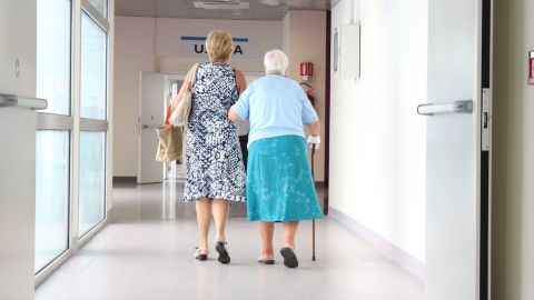 Mujer acompañando su madre al centro. Vista de espaldas