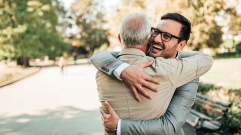 Padre e hijo abrazados sonrientes en la calle