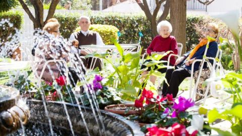 personas atendidas tomando el sol en el jardín de la residencia Dovela