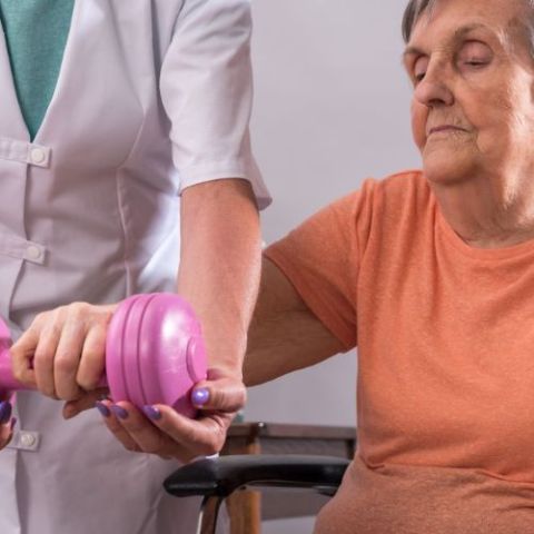 Persona en un centro de día haciendo ejercicio con la profesional