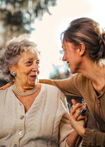 Mujer mayor hablando con su cuidadora